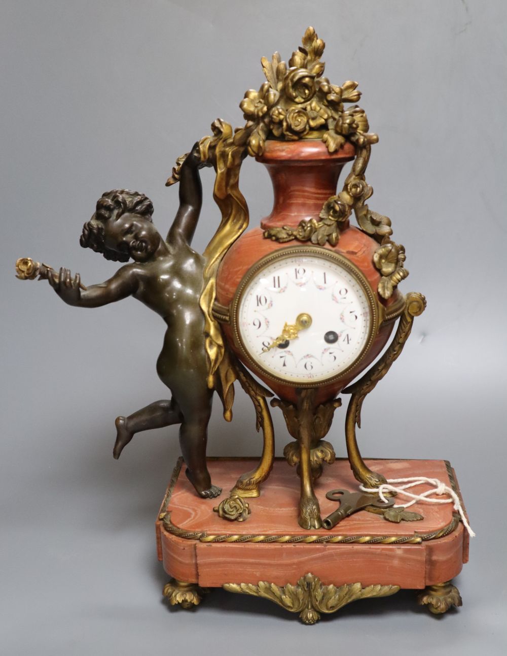 A 19th century French ormolu mounted rouge marble mantel clock, cast with putti, height 36cm